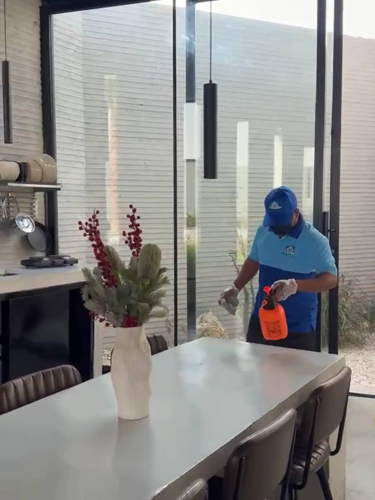 فني ينظّف جداراً زجاجياً في صالة طعام واسعة